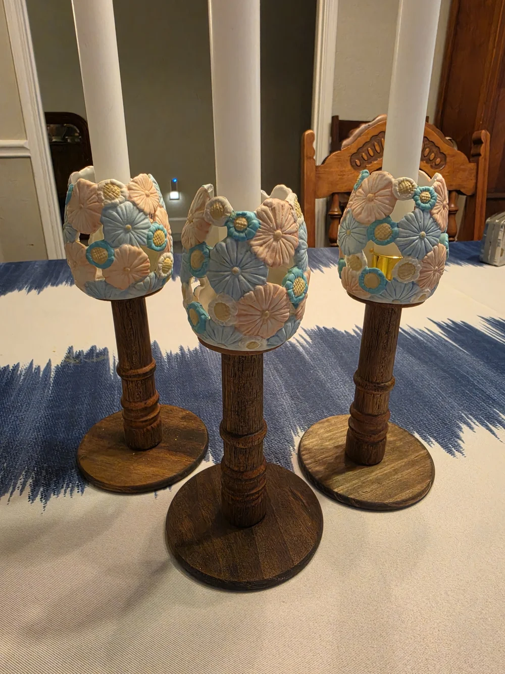 Trio Of Turned dark wood candlestick holders pastel-colored sculpted floral cups